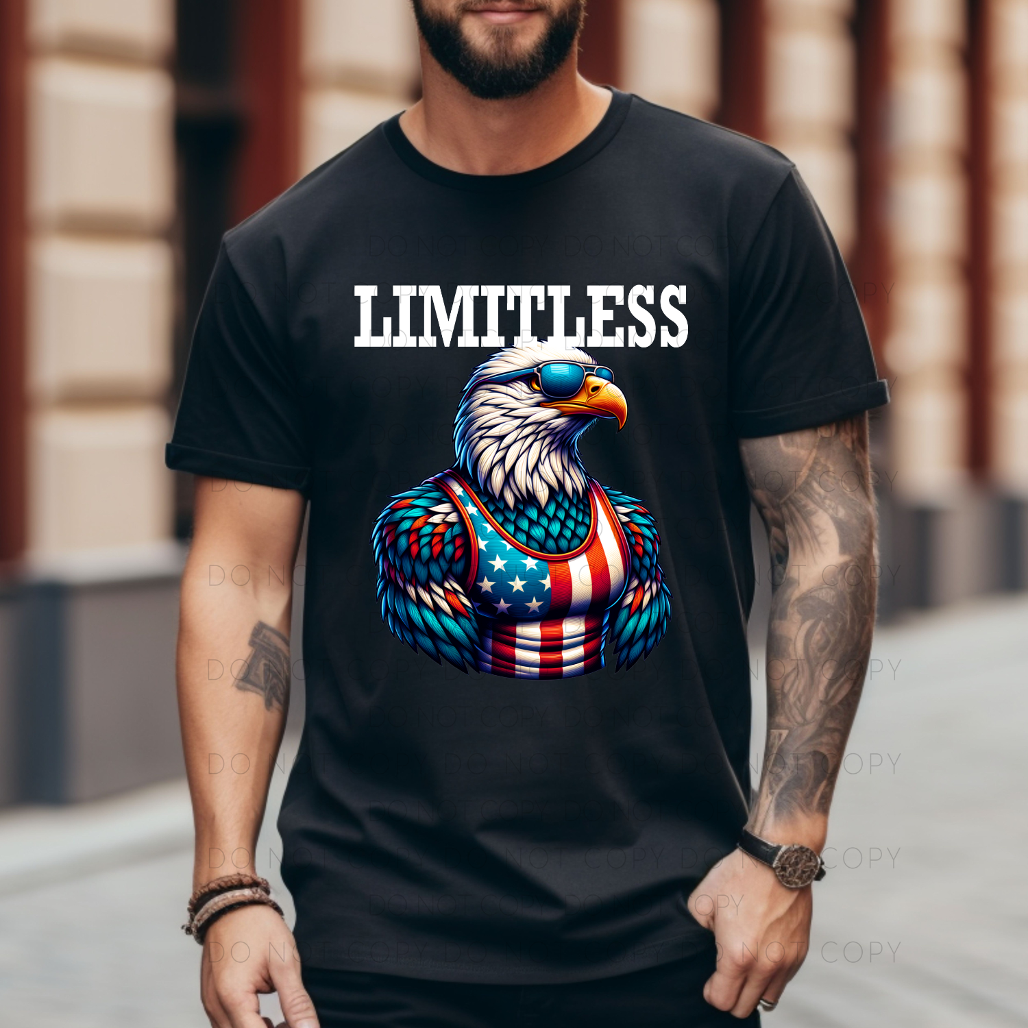 A person wearing a black unisex t-shirt with a colorful graphic of a bald eagle and the word 'LIMITLESS' printed above it.