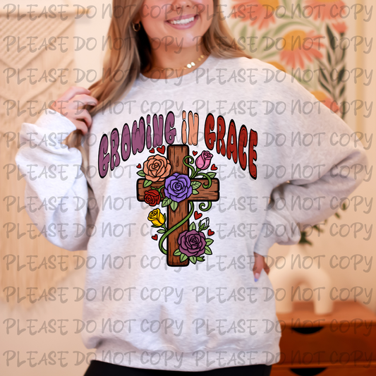 Person wearing a sweatshirt with 'Growing in Grace' design featuring a cross and flowers.