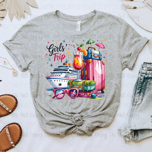 Gray t-shirt with 'Girls' Trip' design featuring a cruise ship, sunglasses, and travel items on a light background.