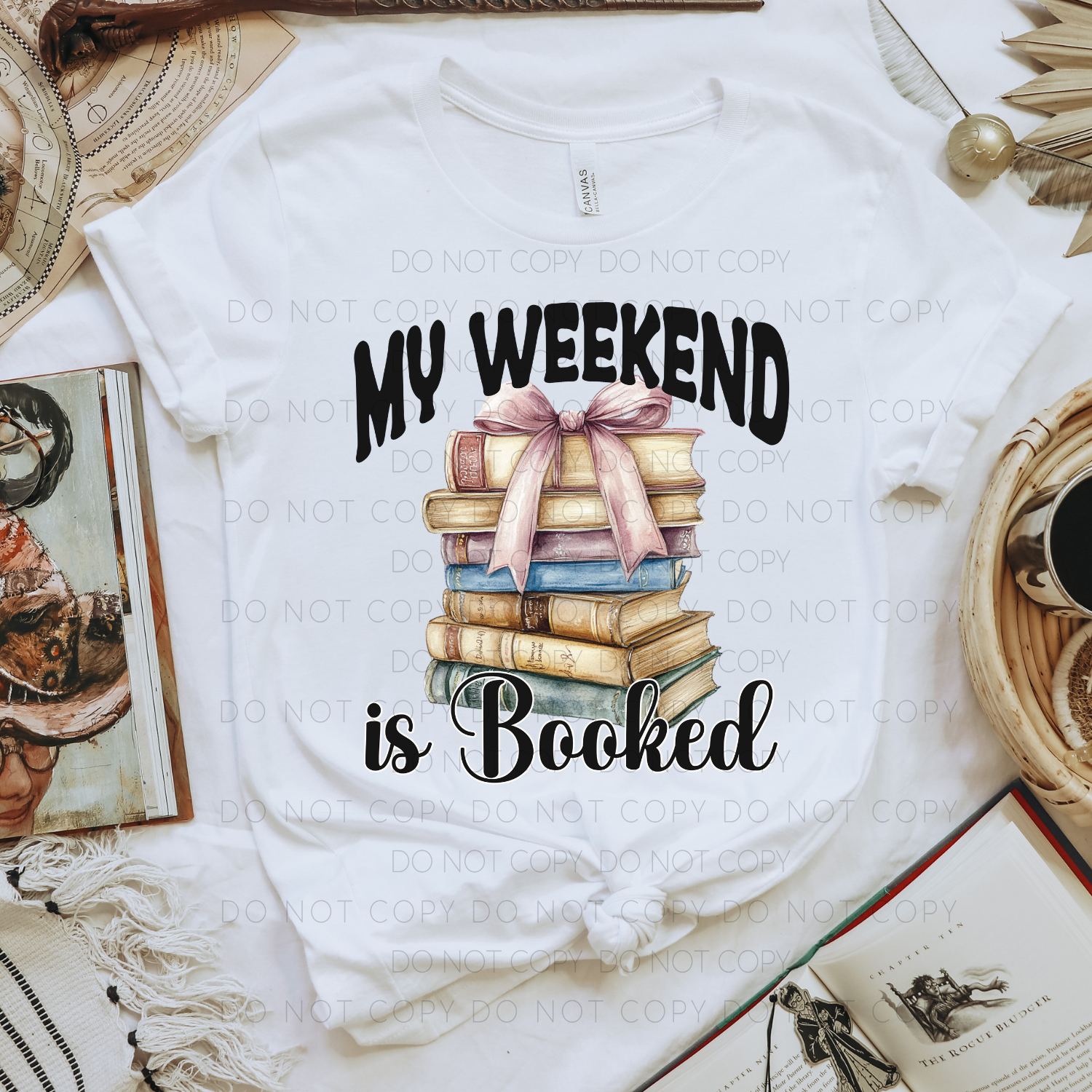A white unisex T-shirt with the text 'MY WEEKEND IS BOOKED' printed on the front, styled with a graphic of stacked books and a bow.